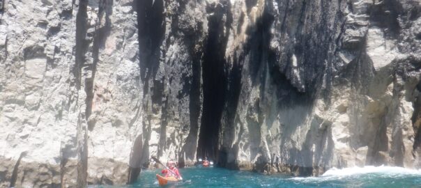 Sea kayaker exploring the Huntsman's Leap on the Pembrokeshire coast.