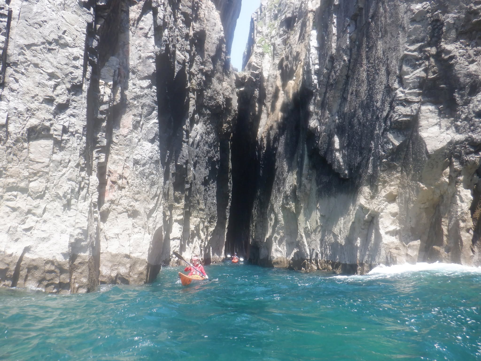 Sea kayaker exploring the Huntsman's Leap on the Pembrokeshire coast.
