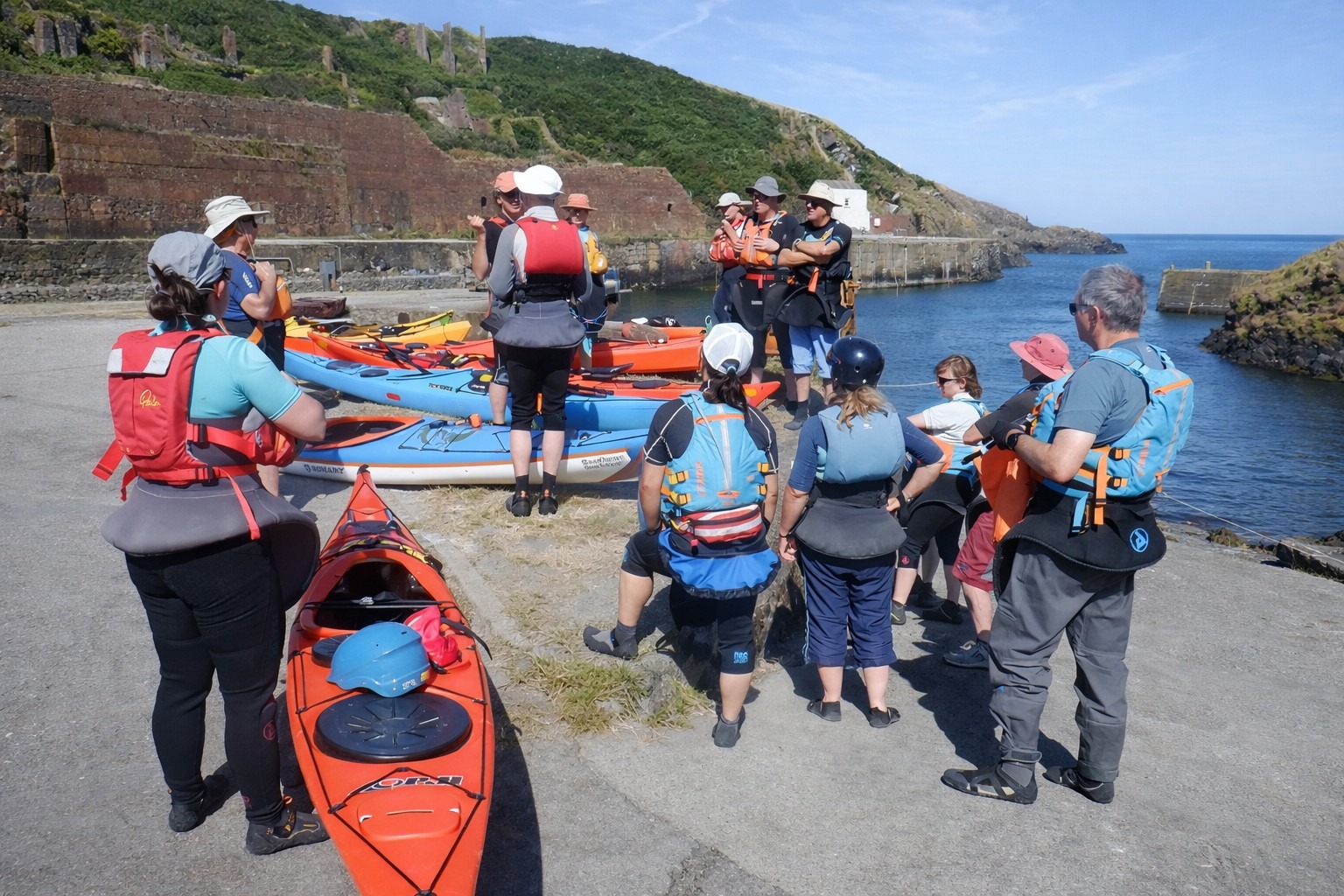 Experienced paddlers discussing sea conditions before launching in Pembrokeshire