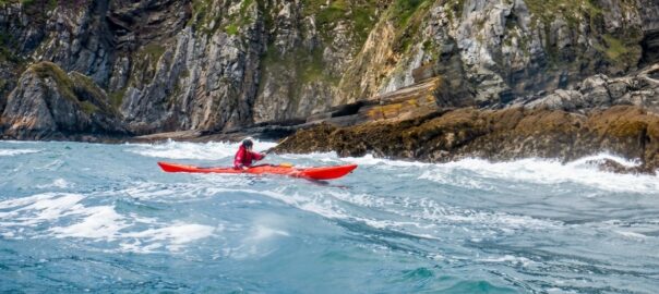 Sea kayak paddler on the Pembrokeshire coast in West Wales