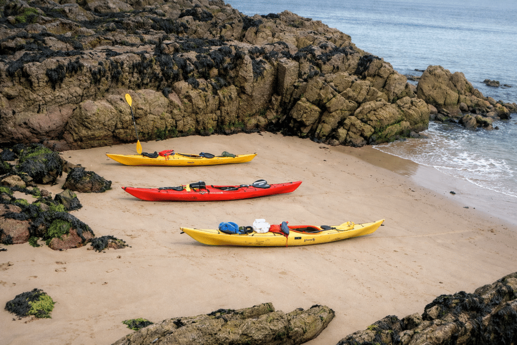 Sea kayakers exploring the Pembrokeshire coastline on a guided kayaking holiday