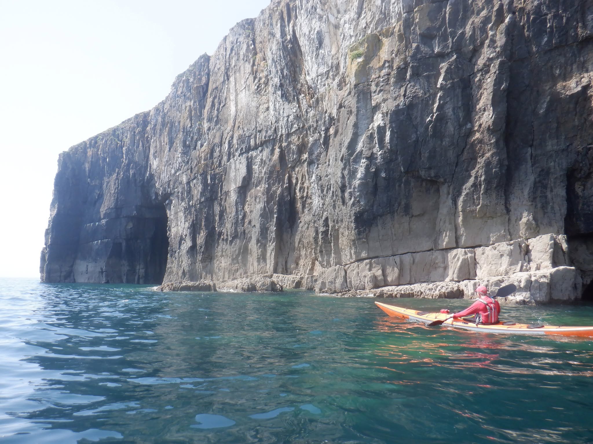 Sea kayakers exploring the Pembrokeshire coast on a guided kayaking holiday